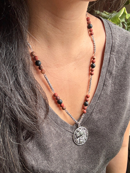 Necklace with a horse pendant worn by a person, focusing on the necklace and its details.