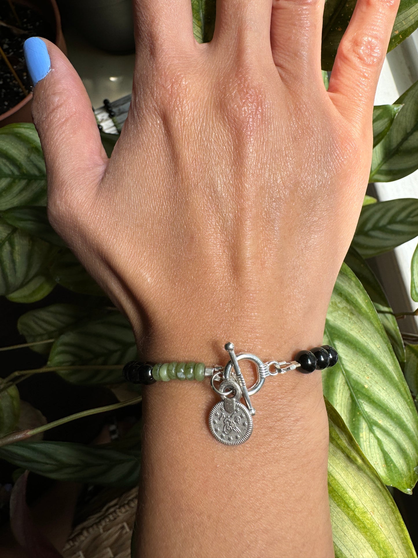 black tourmaline and olive jade beaded bracelet with silver coin wrist view