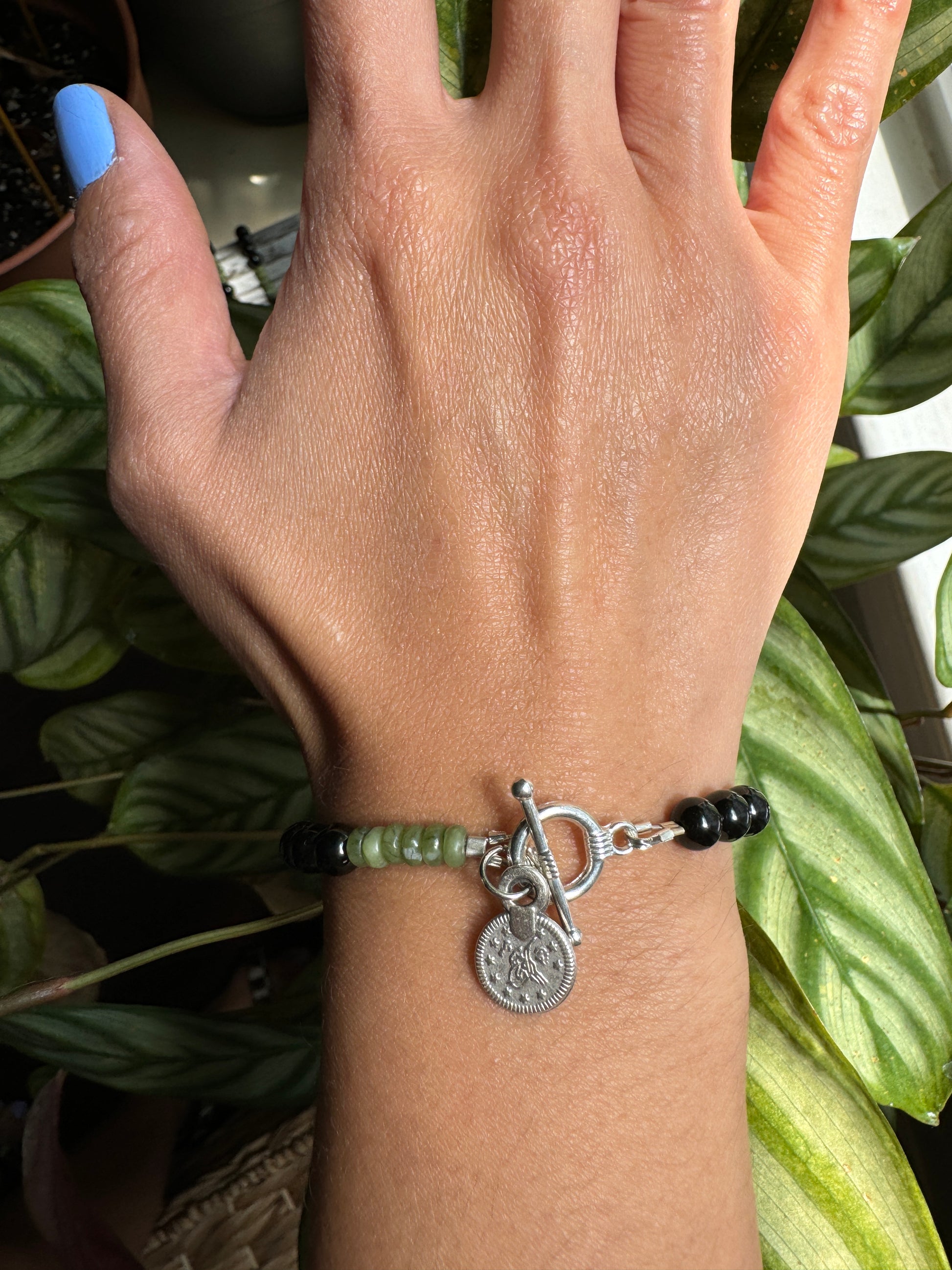 black tourmaline and olive jade beaded bracelet with silver coin wrist view