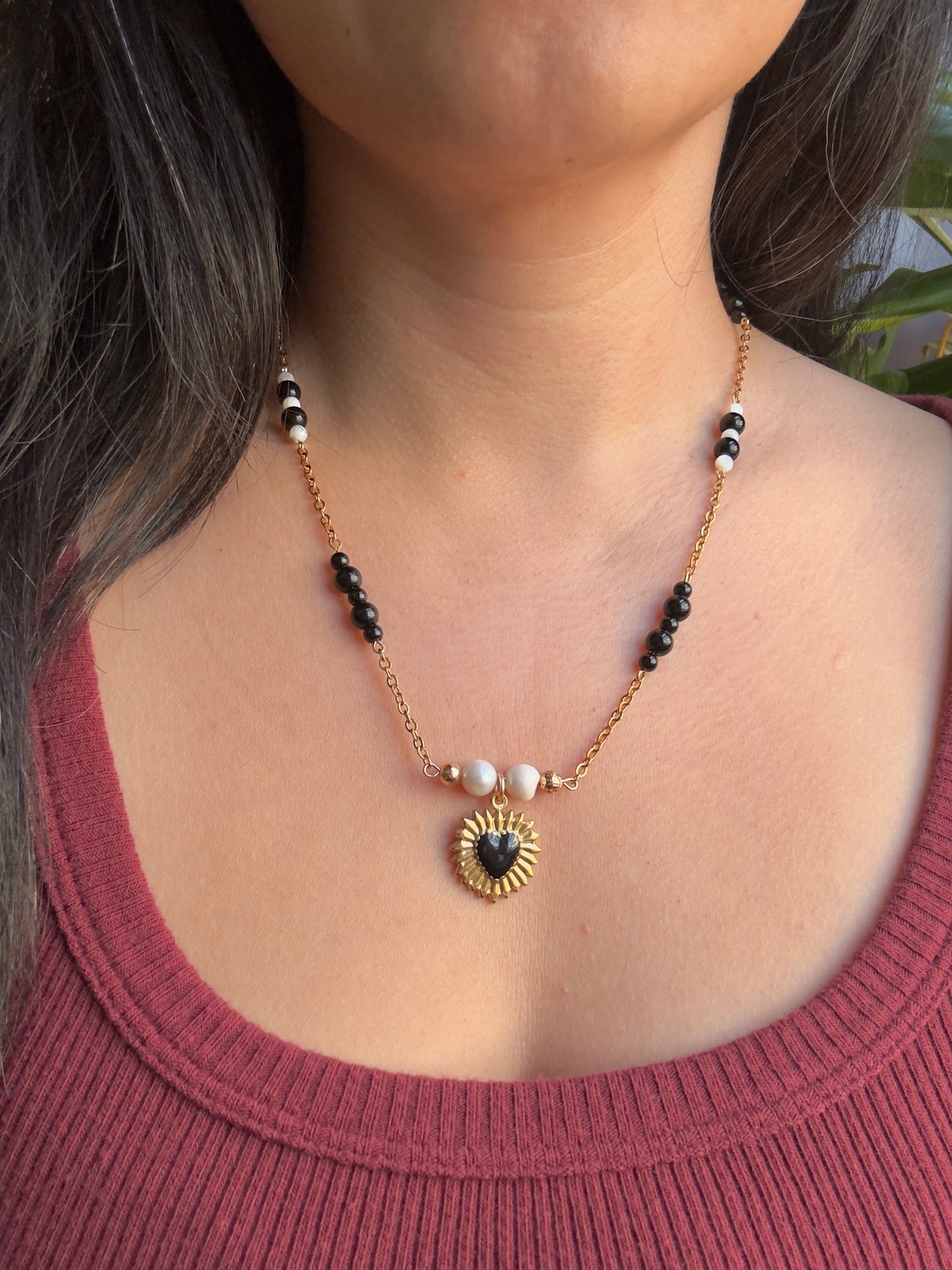 Black heart gold stainless steel pendant on gold stainless steel chain with black jasper and pearl beads on model
