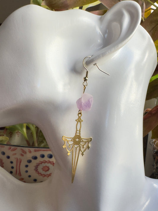 Gold sword earring with amethyst chunk bead on a white mannequin ear