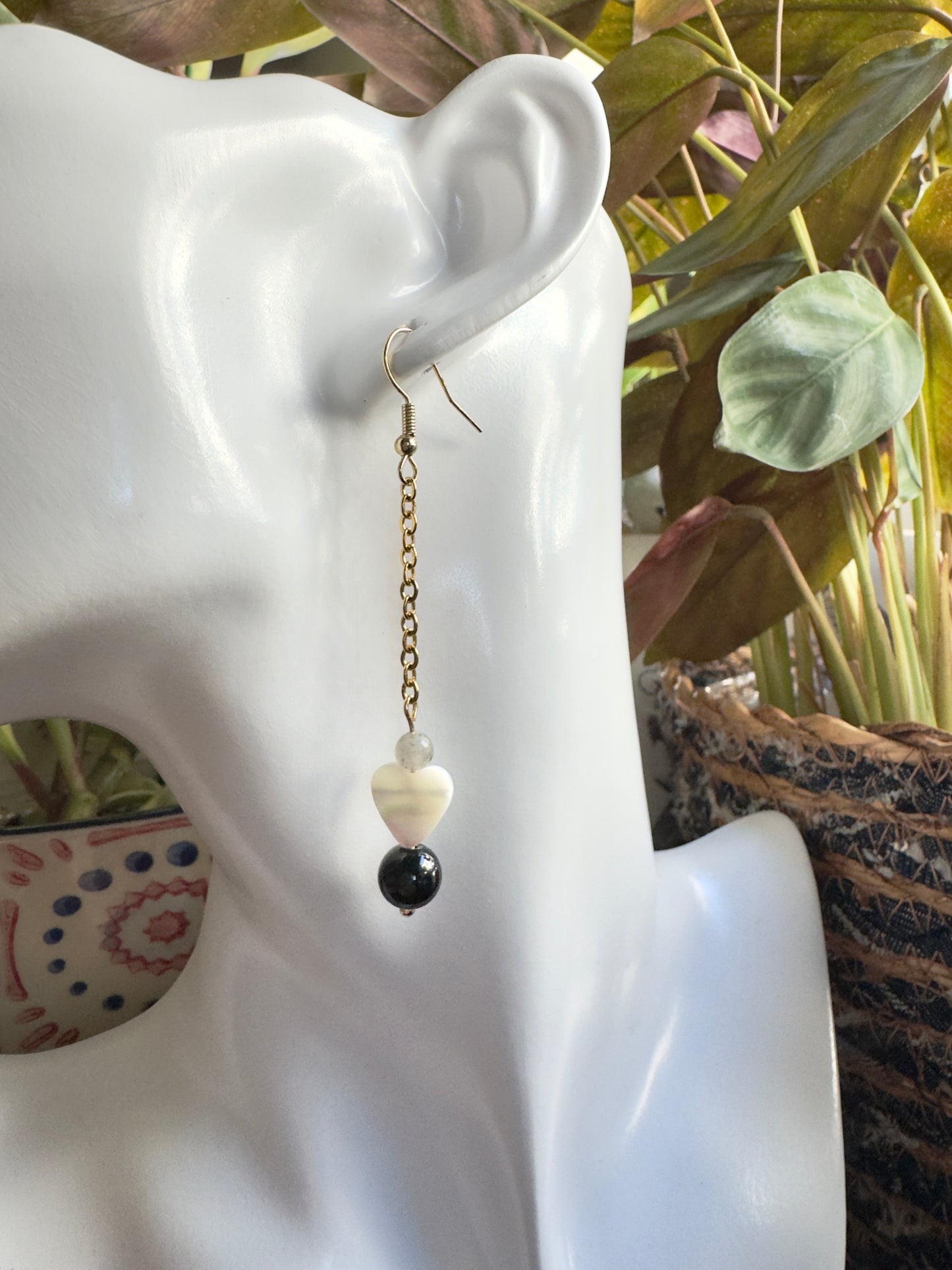 Earring on a mannequin ear with a blurred plant background