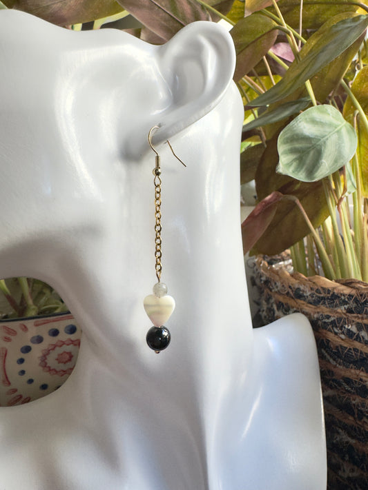 Earring on a mannequin ear with a blurred plant background