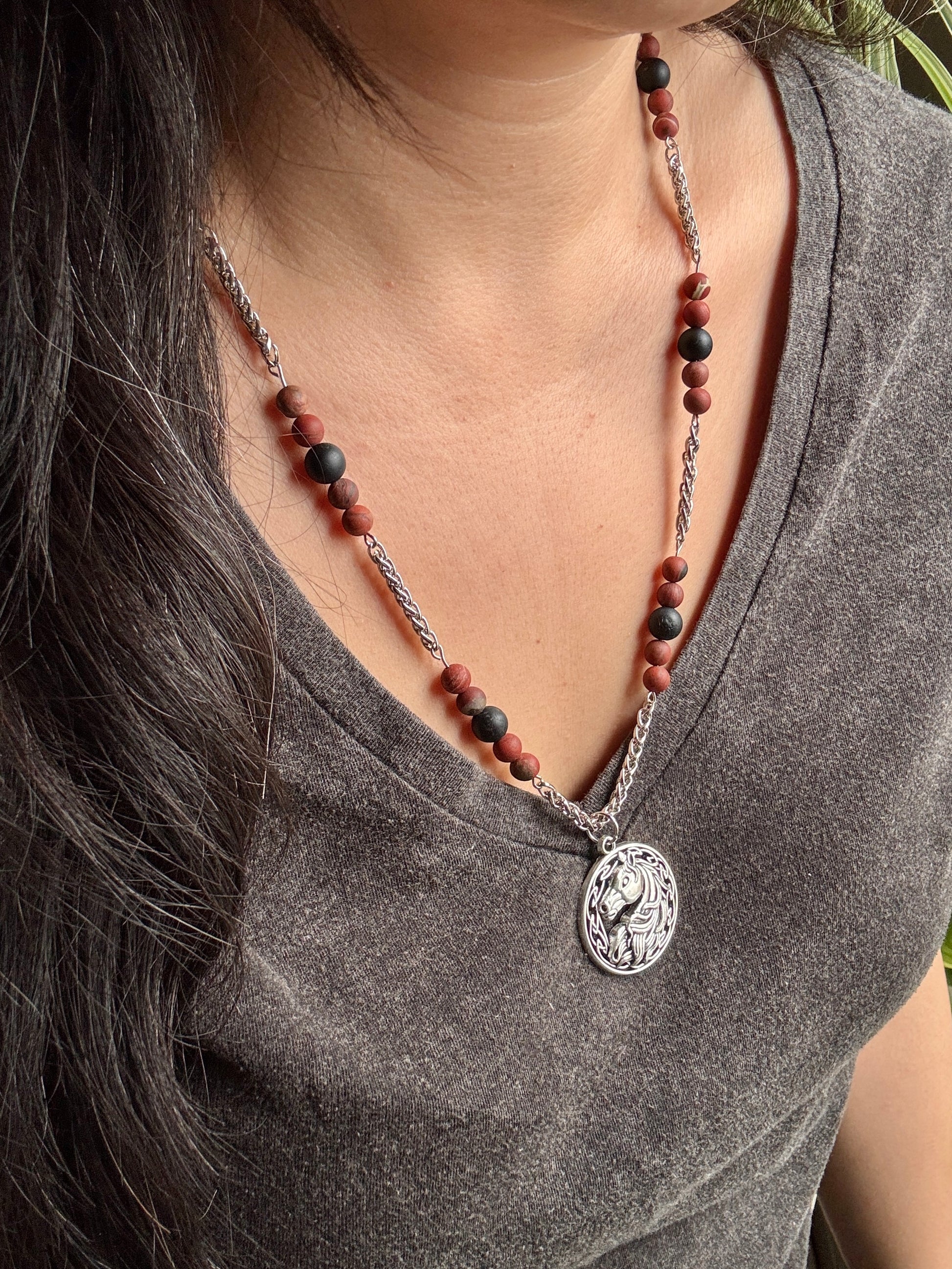 Necklace with a pendant worn by a person, focusing on the necklace and pendant.