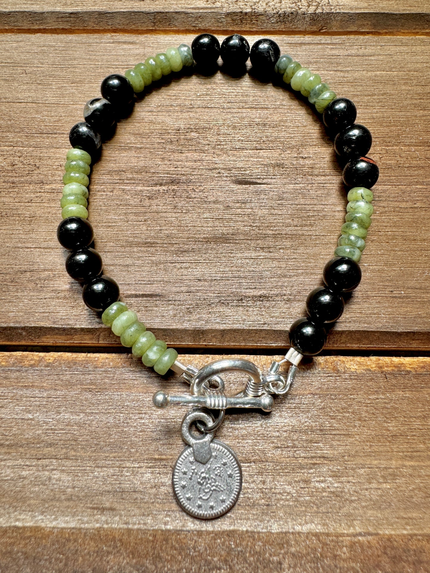 black tourmaline and olive jade beaded bracelet with silver coin charm