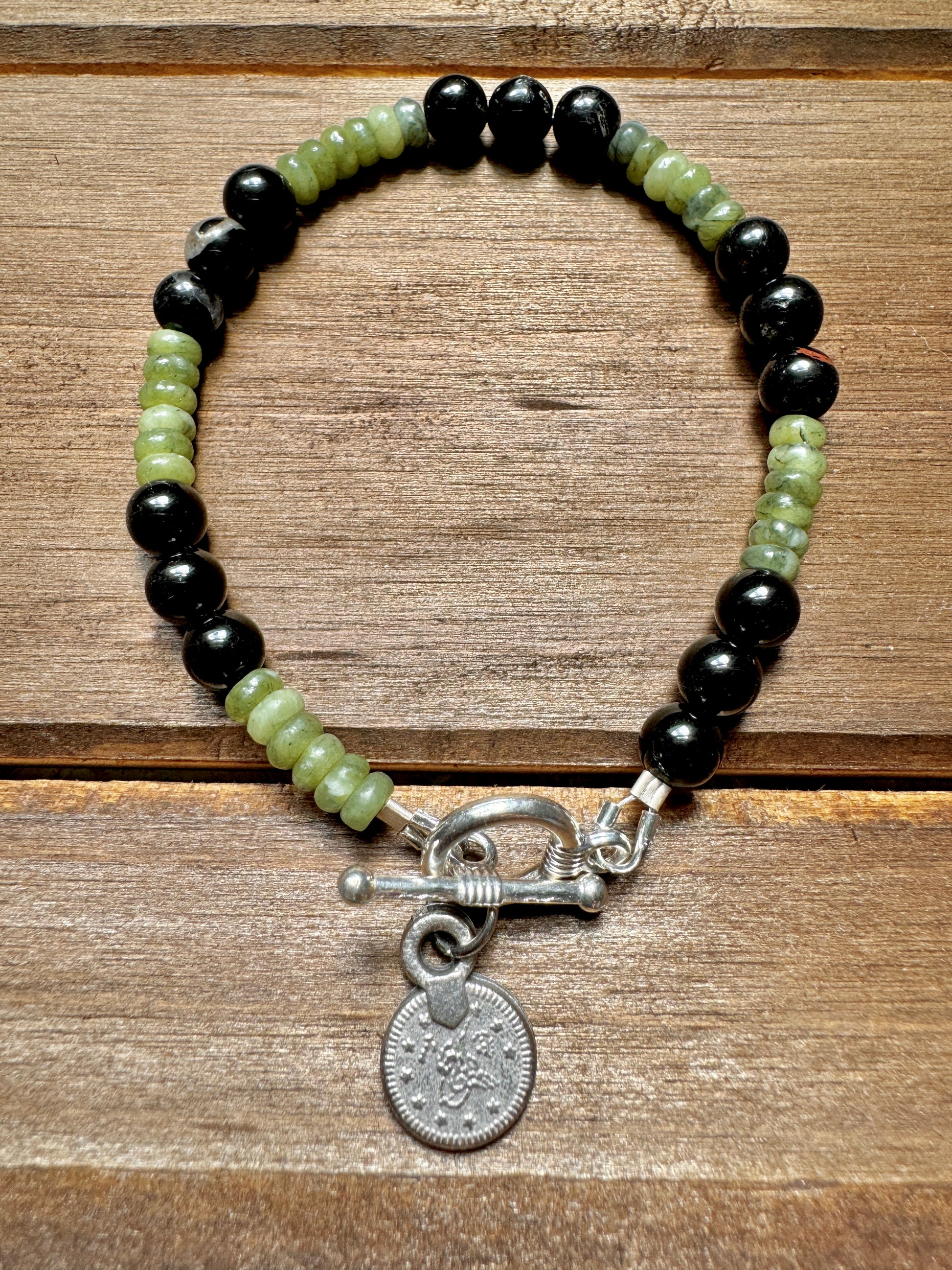 black tourmaline and olive jade beaded bracelet with silver coin charm