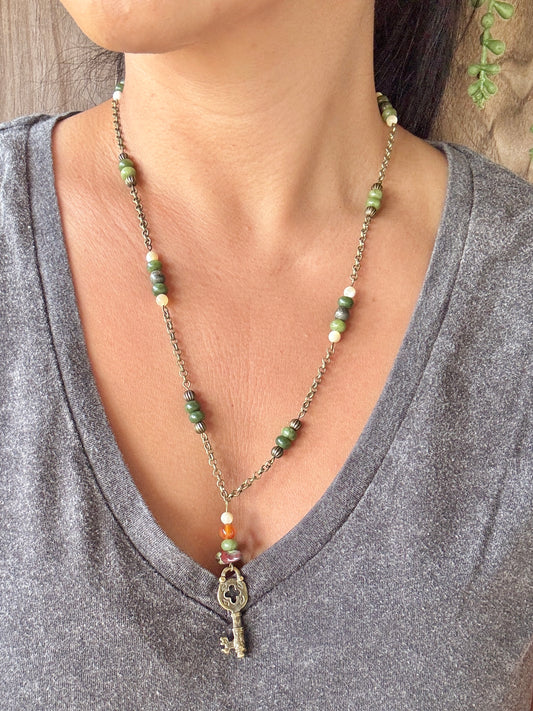Necklace with a key pendant worn by a person in a gray shirt