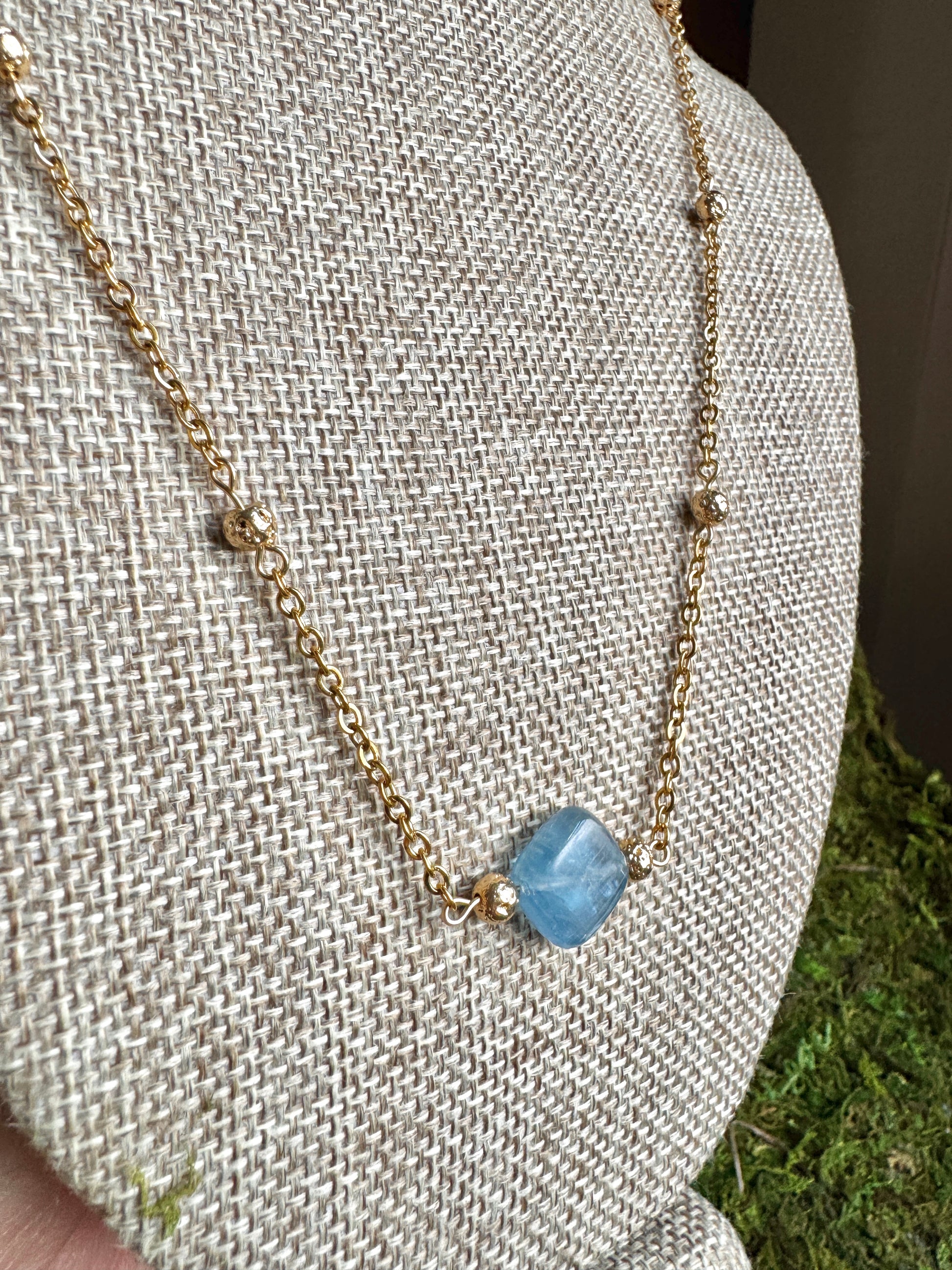 Necklace with a blue pendant on a neutral background