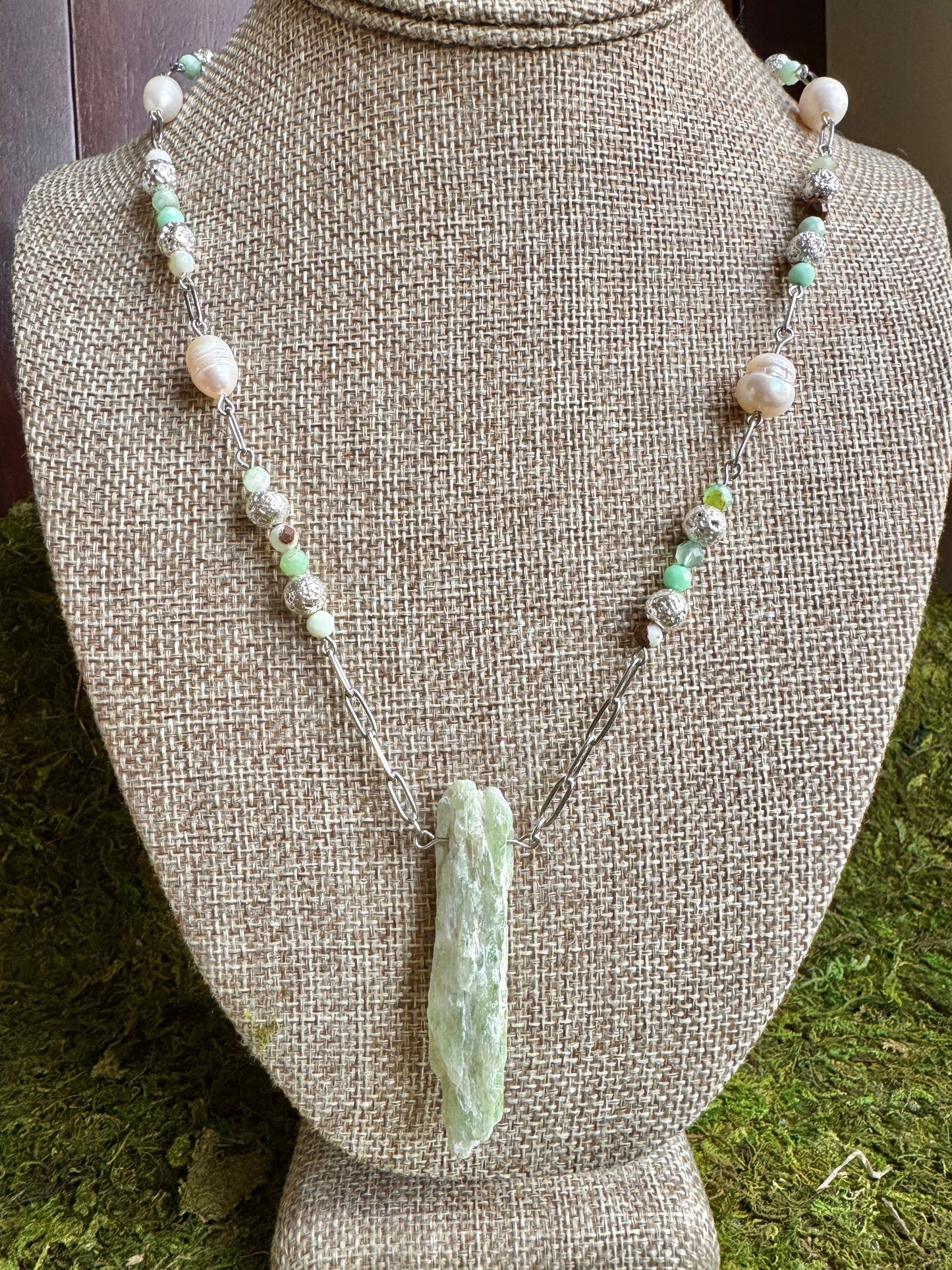 Necklace with green stone pendant on a mannequin bust