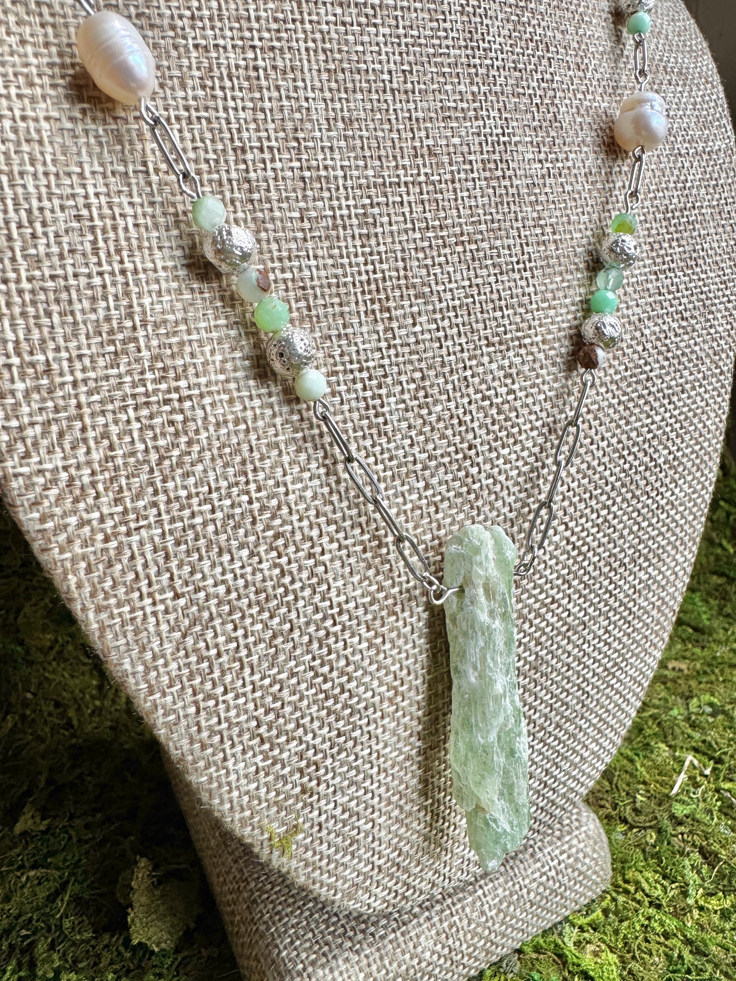 Necklace with a green stone pendant on a textured surface