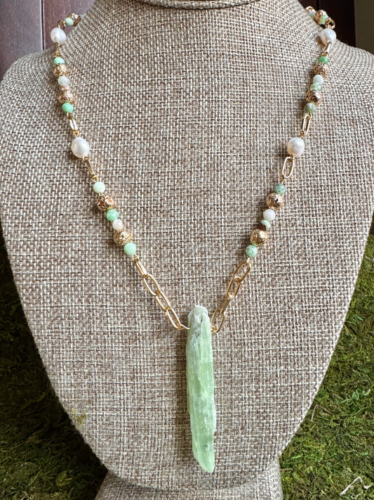 Necklace with green pendant on a gray mannequin bust