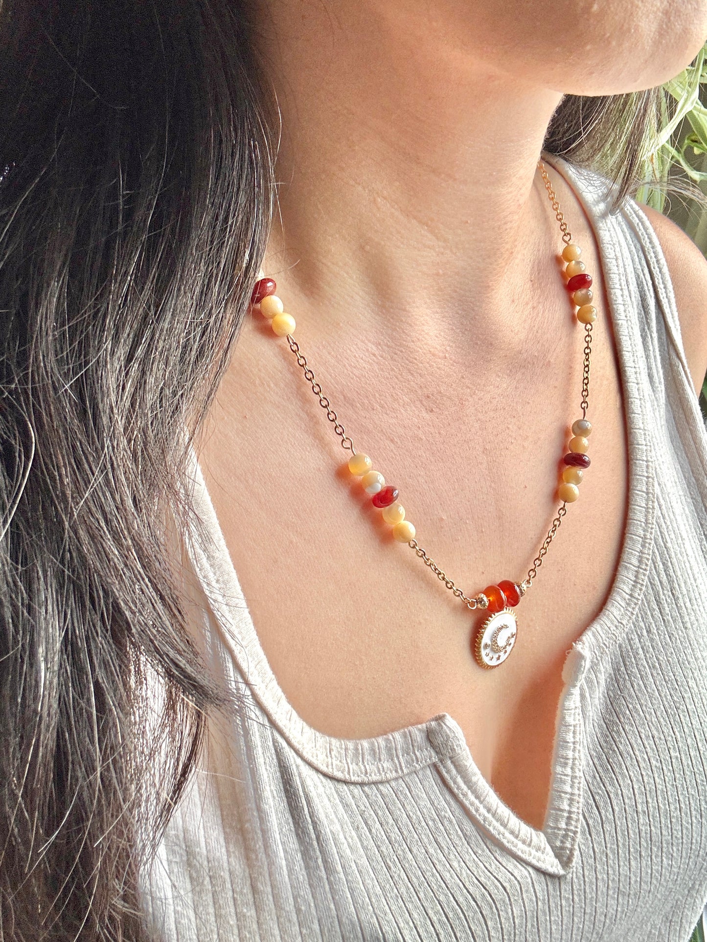 Necklace with beads and a pendant worn by a person