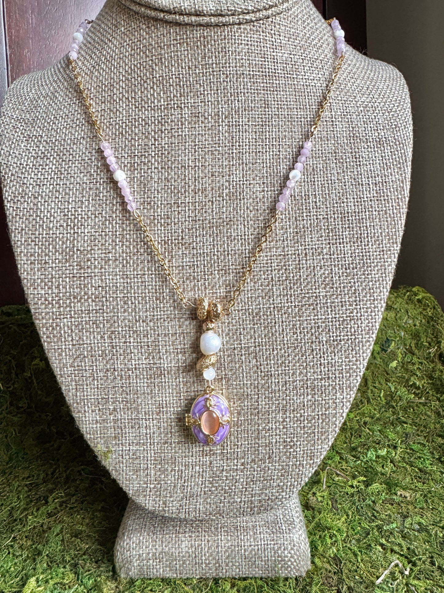 Necklace with a pendant on a mannequin bust against a green grass background