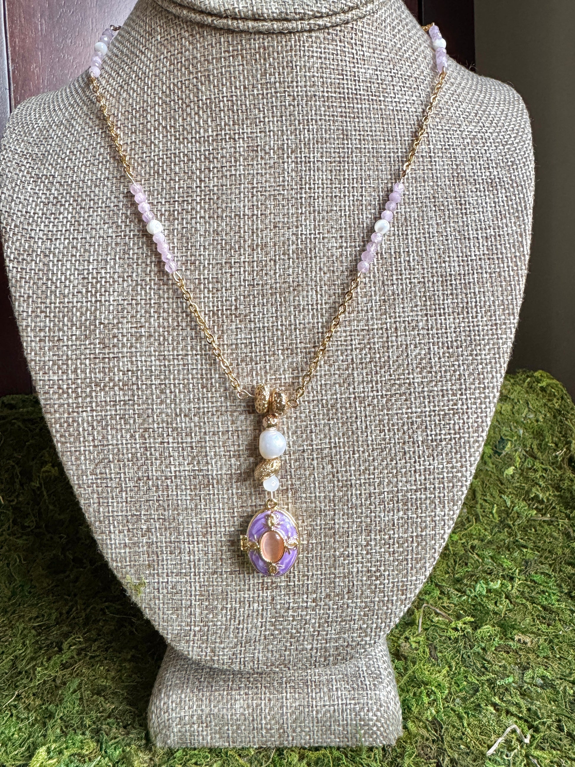 Necklace with a pendant on a mannequin bust against a green grass background