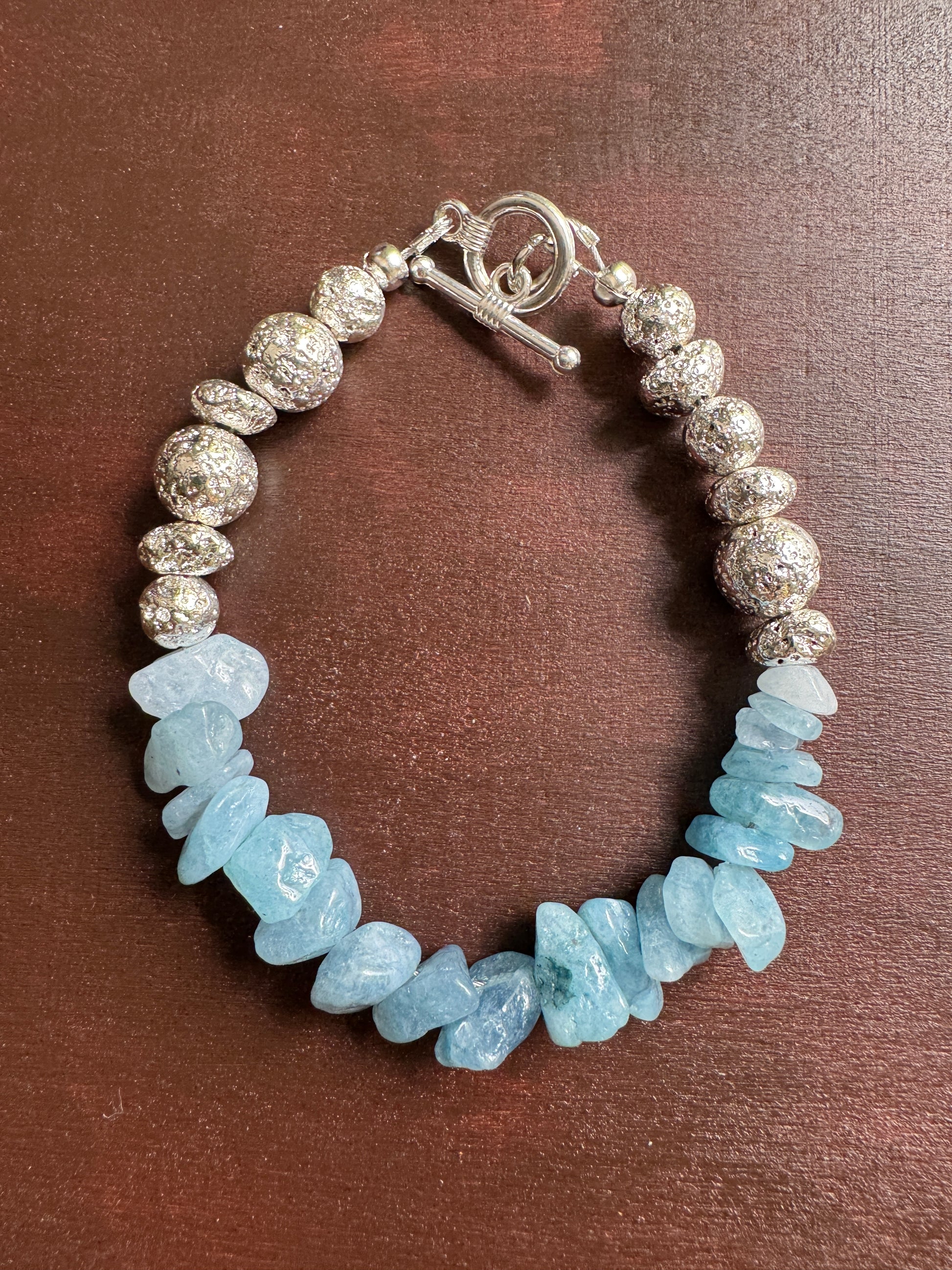 Bracelet with blue beads and silver clasp on a brown background