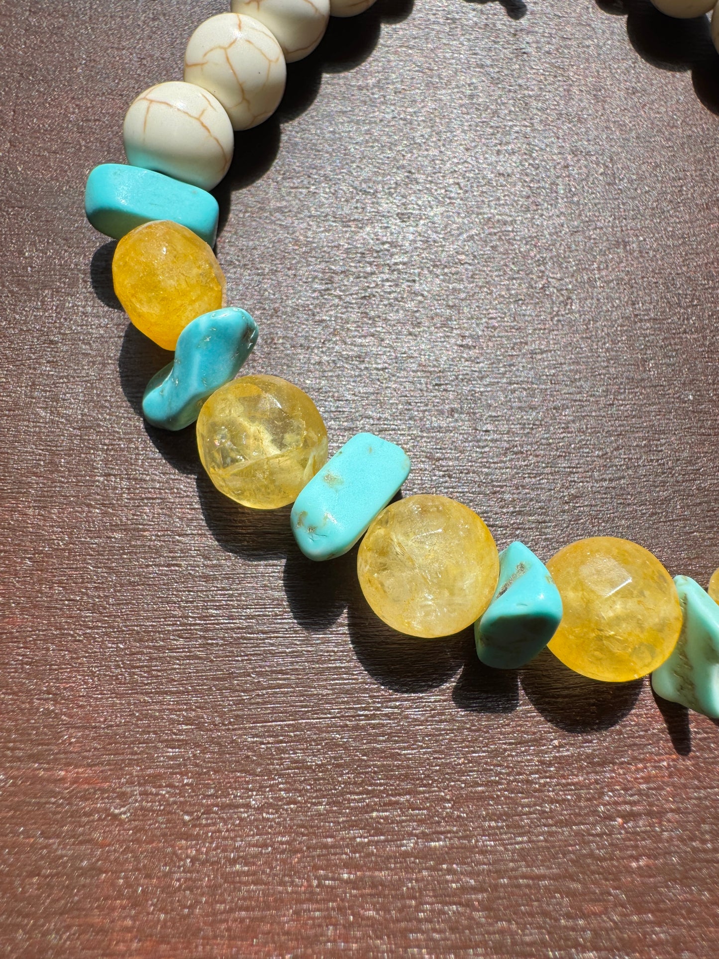 Bracelet with turquoise and yellow beads on a wooden surface