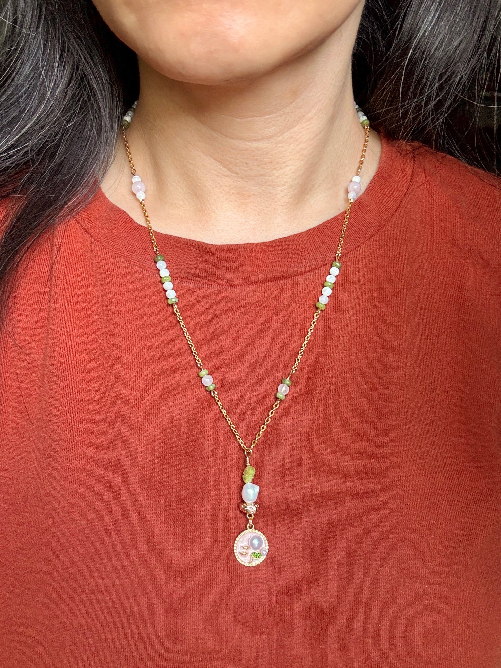 Necklace with colorful beads worn by a person against a red shirt background