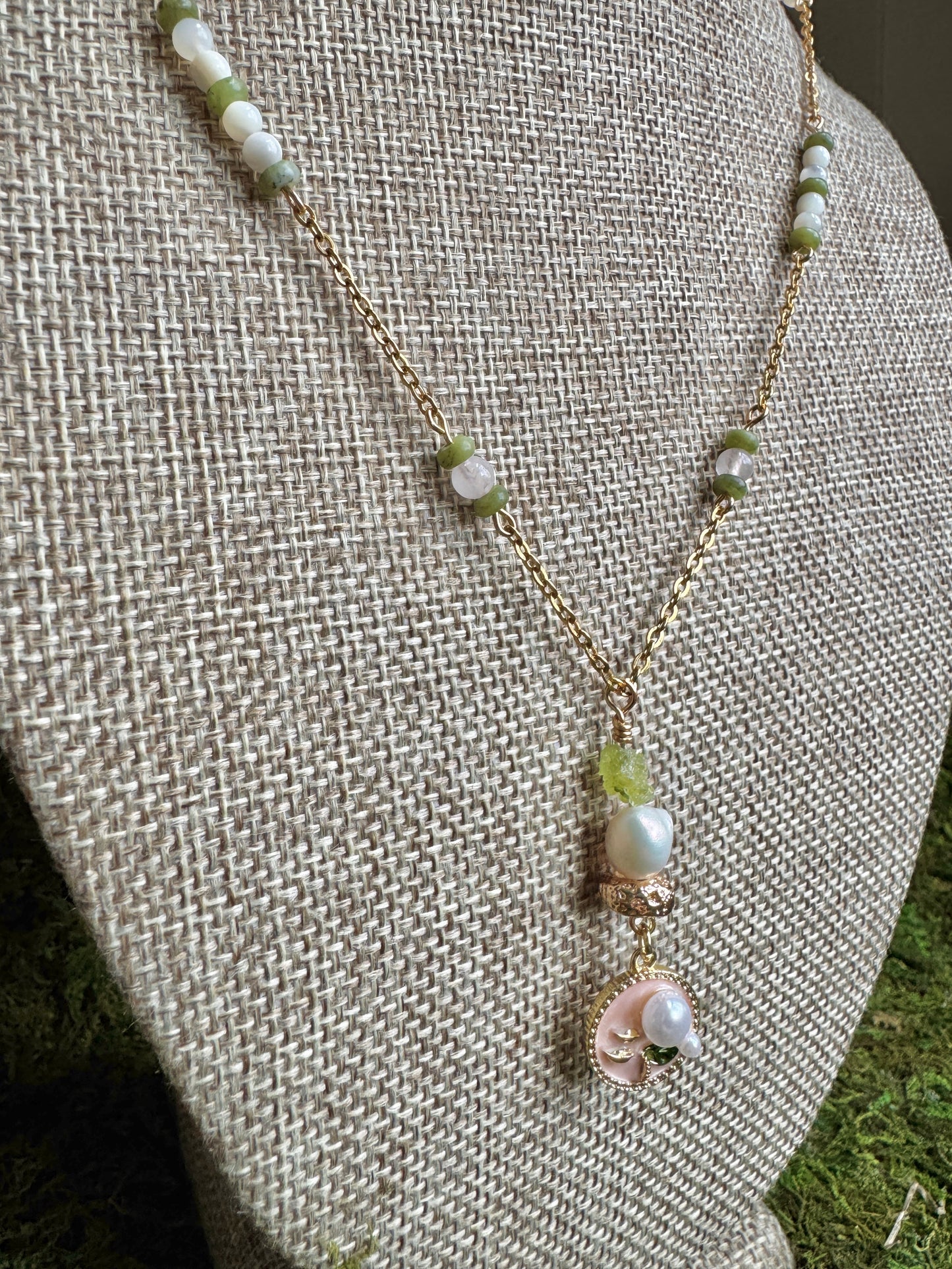 Pearl necklace with a pendant on a textured beige surface