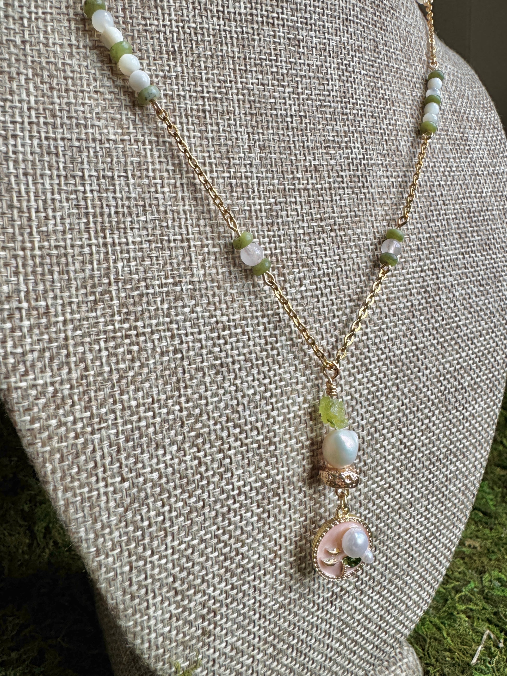 Pearl necklace with a pendant on a textured beige surface